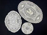 three pieces of lace on a black table cloth