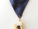 a gold medal with a blue ribbon around it