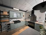 une cuisine équipée d'une cuisinière, d'un four et d'étagères