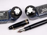 two pens and a pen holder on a table