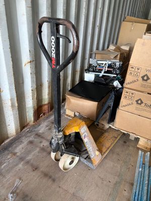 a fork truck with a cart in the middle of the floor