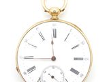 a gold pocket watch with roman numerals on the face