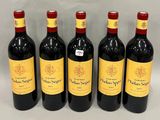 four bottles of wine are lined up on a white surface