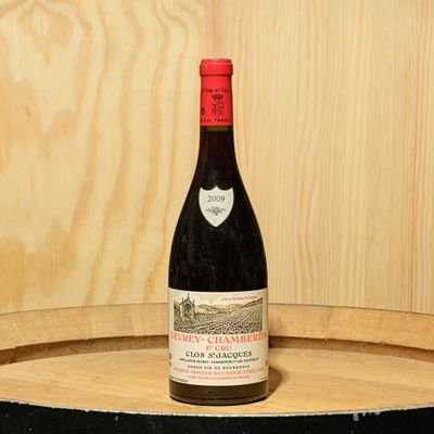 a bottle of wine sitting on top of a barrel