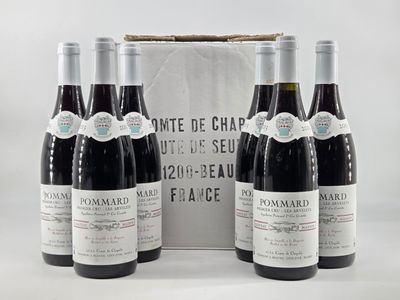three bottles of red wine sit in front of a white box
