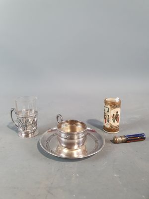 un plateau en argent sur lequel sont posés une tasse et une soucoupe en argent