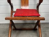 une chaise en bois sur laquelle est posé un coussin rouge