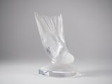 clear glass sculpture of a bird on a clear base on a white surface