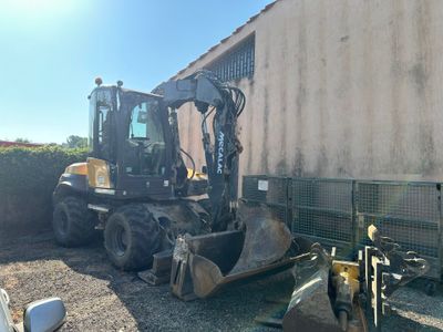 une photo d'un engin de chantier garé devant un immeuble