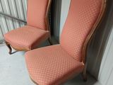 une paire de fauteuils rembourrés roses dans un coin de la pièce