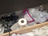 a drawer with a bunch of clothes and a roll of toilet paper