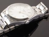 a silver watch that is sitting on a black surface