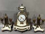 a white and gold clock sitting on top of a table