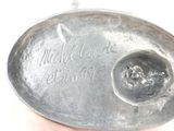 someone is holding a silver spoon with writing on it