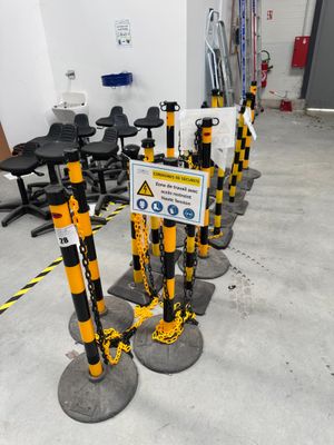 de nombreux poteaux jaunes et noirs sur lesquels sont accrochés des panneaux, dans une pièce