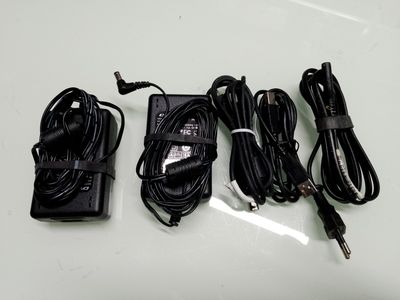 trois cordons d'alimentation et un chargeur posés sur une table