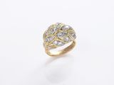 gros plan d'une bague en or et diamants sur une surface blanche