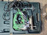 a green and black tool box with tools on the floor