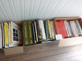 de nombreux livres rangés dans une boîte posée par terre