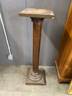 a wooden pedestal with a wooden top and a wooden base