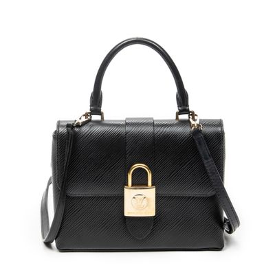 un sac à main noir muni d'un fermoir doré sur la poignée