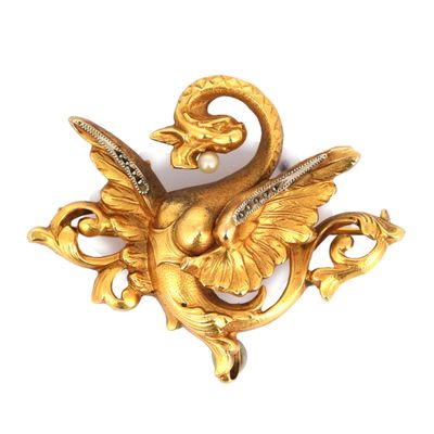 une image représentant une broche en or sur laquelle figure un oiseau