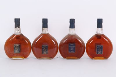 trois bouteilles de whisky posées les unes à côté des autres sur une surface blanche