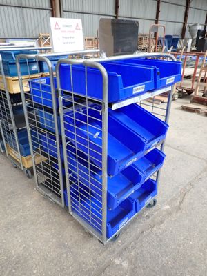 un chariot métallique muni de bacs bleus et d'un panneau posé dessus