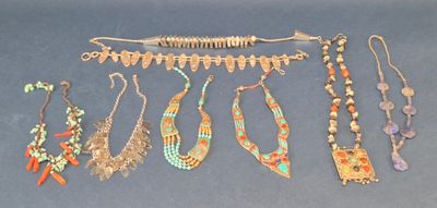 many different necklaces and bracelets on a blue surface