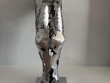a metal sculpture of a man ' s head on a metal base
