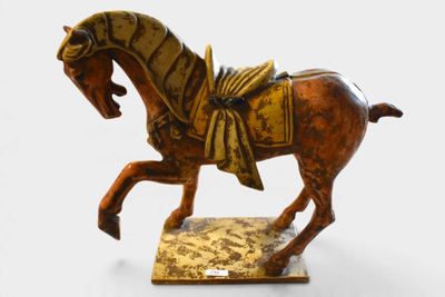 statue d'un cheval avec une selle sur le dos