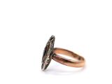a close up of a ring on a white surface with a diamond