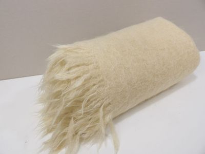 a roll of wool sitting on a table with a white background