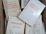 Plusieurs livres se trouvent dans une boîte en carton posée sur une table