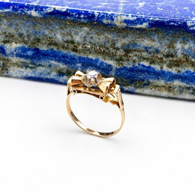 a close up of a gold ring with a stone in the background