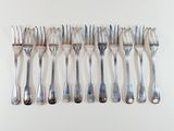 a lot of forks and spoons on a white surface