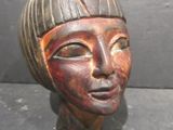 statue of a woman ' s head with a striped hat on it