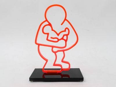 an orange neon sculpture of a man holding a baby on a black base