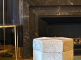 a white ottoman sitting in front of a fireplace in a living room