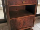 a wooden shelf with a drawer on top of it