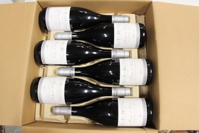 six bouteilles de vin dans un carton sur une table
