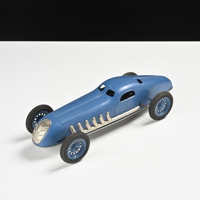 une petite voiture bleue posée sur une surface blanche