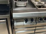 une cuisine en inox équipée d'une cuisinière et d'un lave-vaisselle