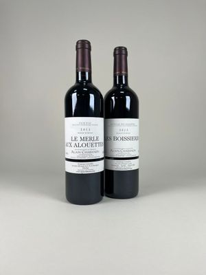 two bottles of red wine sitting next to each other on a table