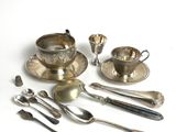 a lot of silver spoons and silverware on the table