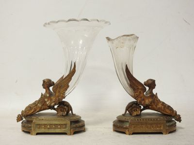 une paire de vases anciens en bronze et en verre posés sur une table
