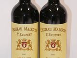 two bottles of wine sitting on top of a table next to each other