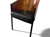 a wooden chair with a black leather seat on a white background