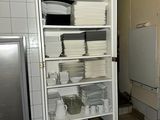 a tall cabinet filled with dishes and dishes in a kitchen