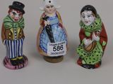 three figurines of people dressed in different costumes and hats